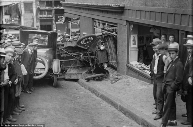 Photographer Leslie Jones had to part crowds of onlookers to capture this accident in downtown Boston. An out of control car collided with a shop front, smashing windows and ending up on its side