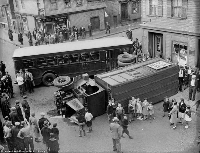 Another view of the same accident shows eager children posing with the upturned truck. it also demonstrates how close the vehicles came to nearby buildings